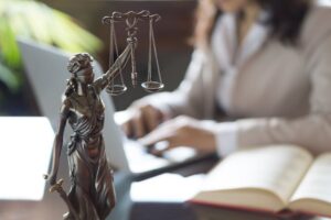 Lawyer,Office.,Statue,Of,Justice,With,Scales,And,Lawyer,Working