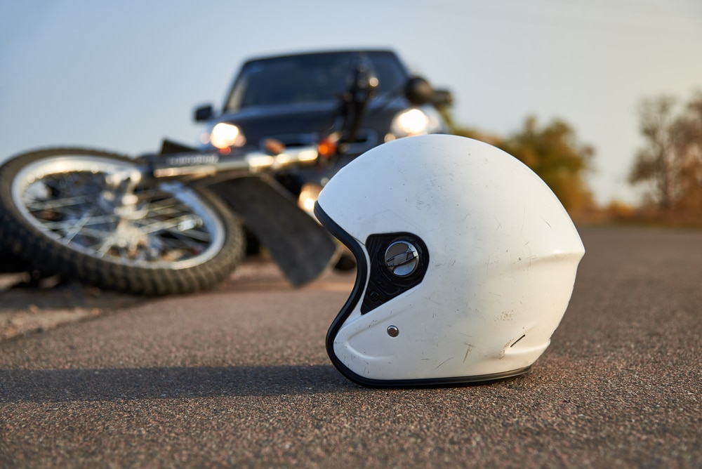 A motorcycle and helmet on the ground after a motorcycle accident