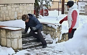 Senior man slipping on icy steps in the winter time.