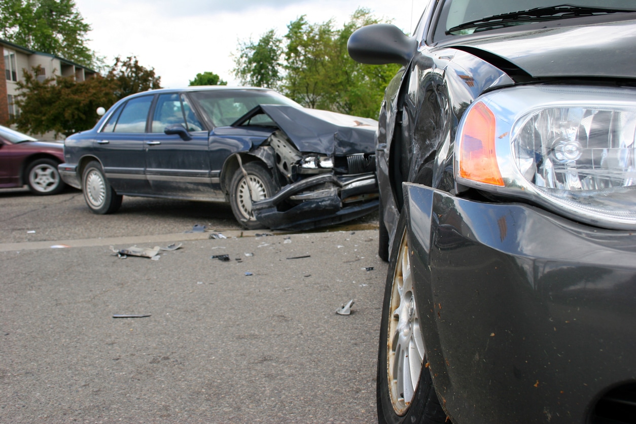 Two damaged vehicles at the scene of a work-related car accident.