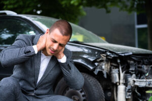A man holding his neck after a work-related car accident