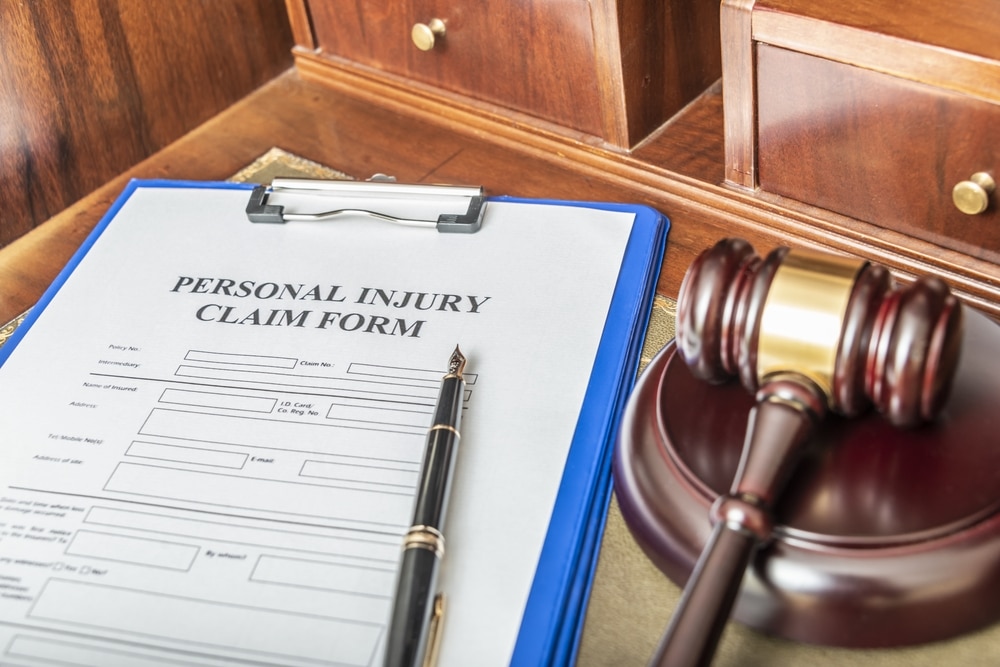 A personal injury claim form on a table next to a gavel