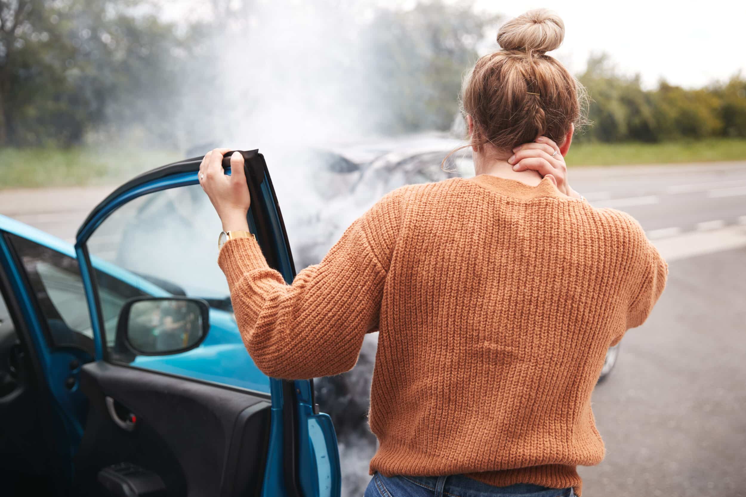 A woman holding her neck after a car accident