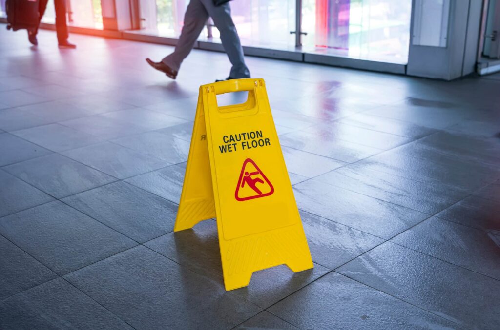 A "Caution: Wet Floor" sign in a grocery store